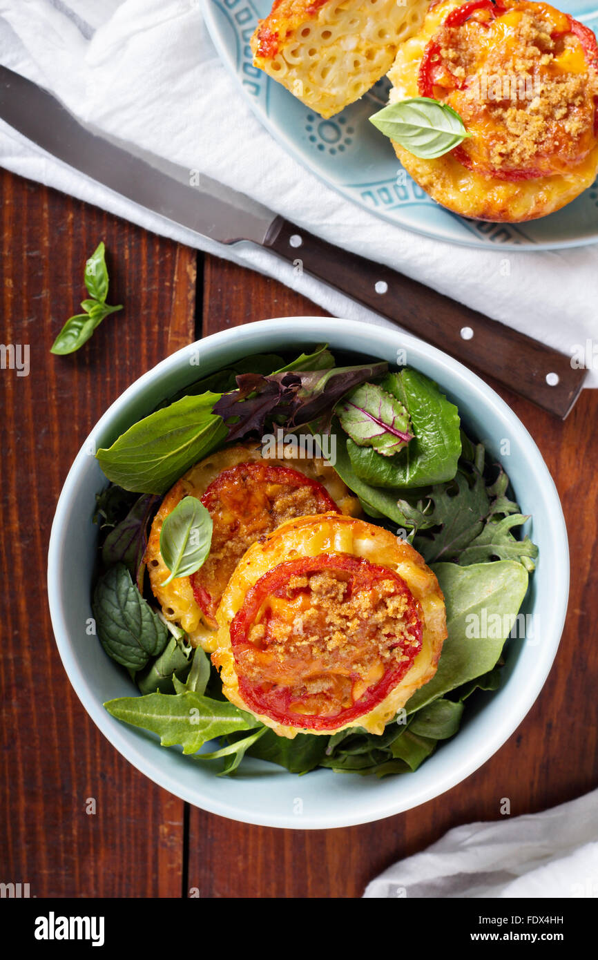 Makkaroni und Käse in Muffinformen mit Tomaten Stockfoto