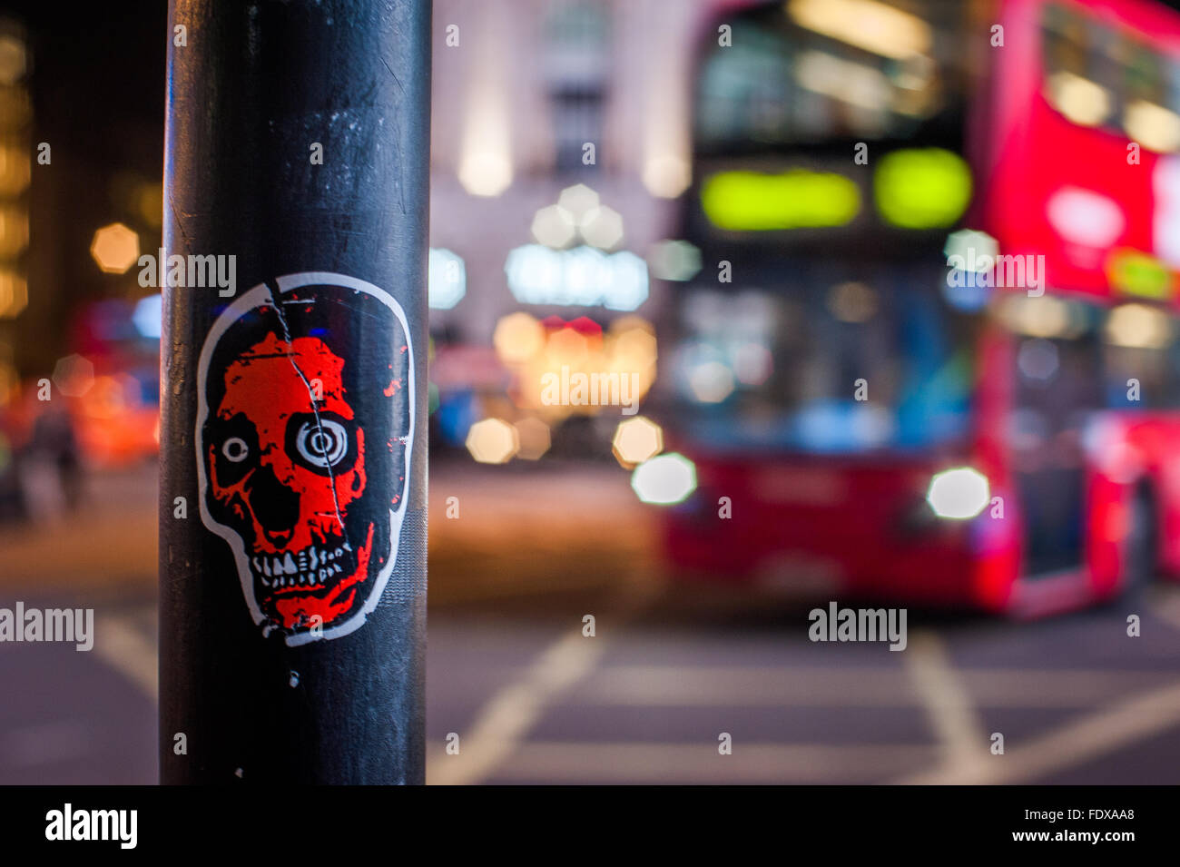 Unheimliche Totenkopf-Aufkleber auf der Pole in der Nacht im Zentrum von London Stockfoto