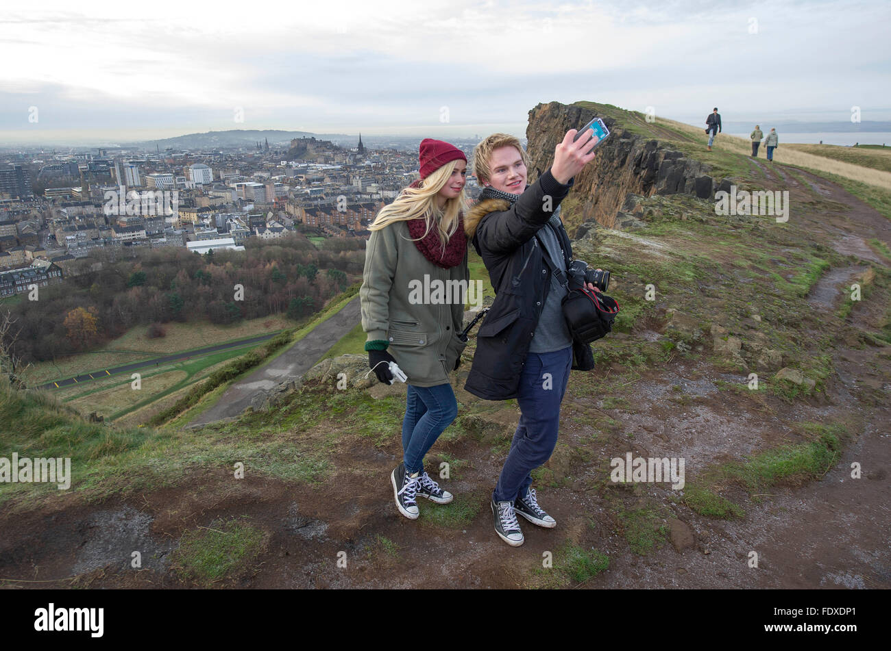 Edinburgh, Schottland.   Norwegische Studenten nehmen Sie ein Selbstporträt auf Salisbury Crags Holyrood Park mit Edinburgh Castle und die Altstadt als Kulisse. Stockfoto