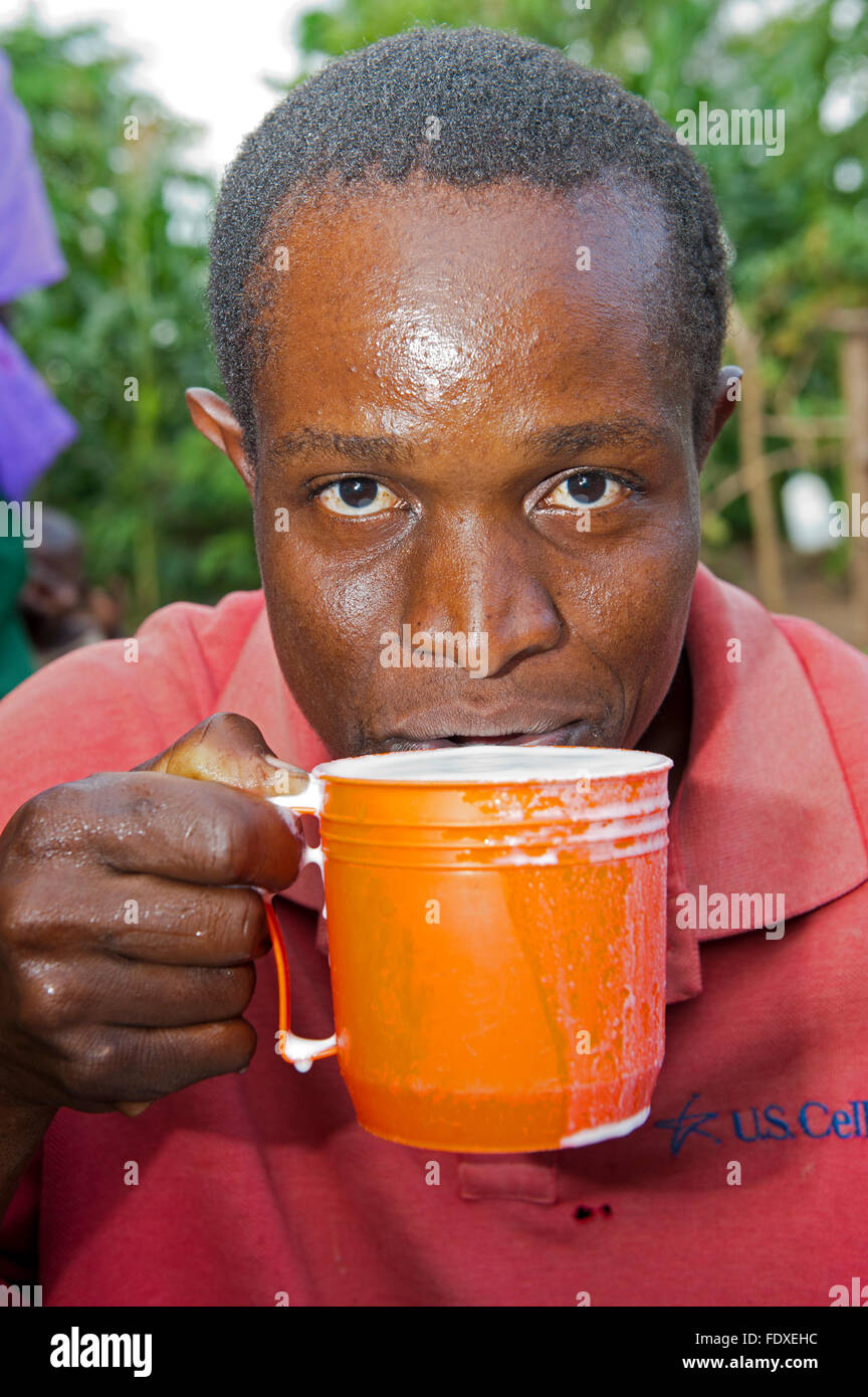 Man trinkt ein Glas frische Kuhmilch, Uganda. Stockfoto