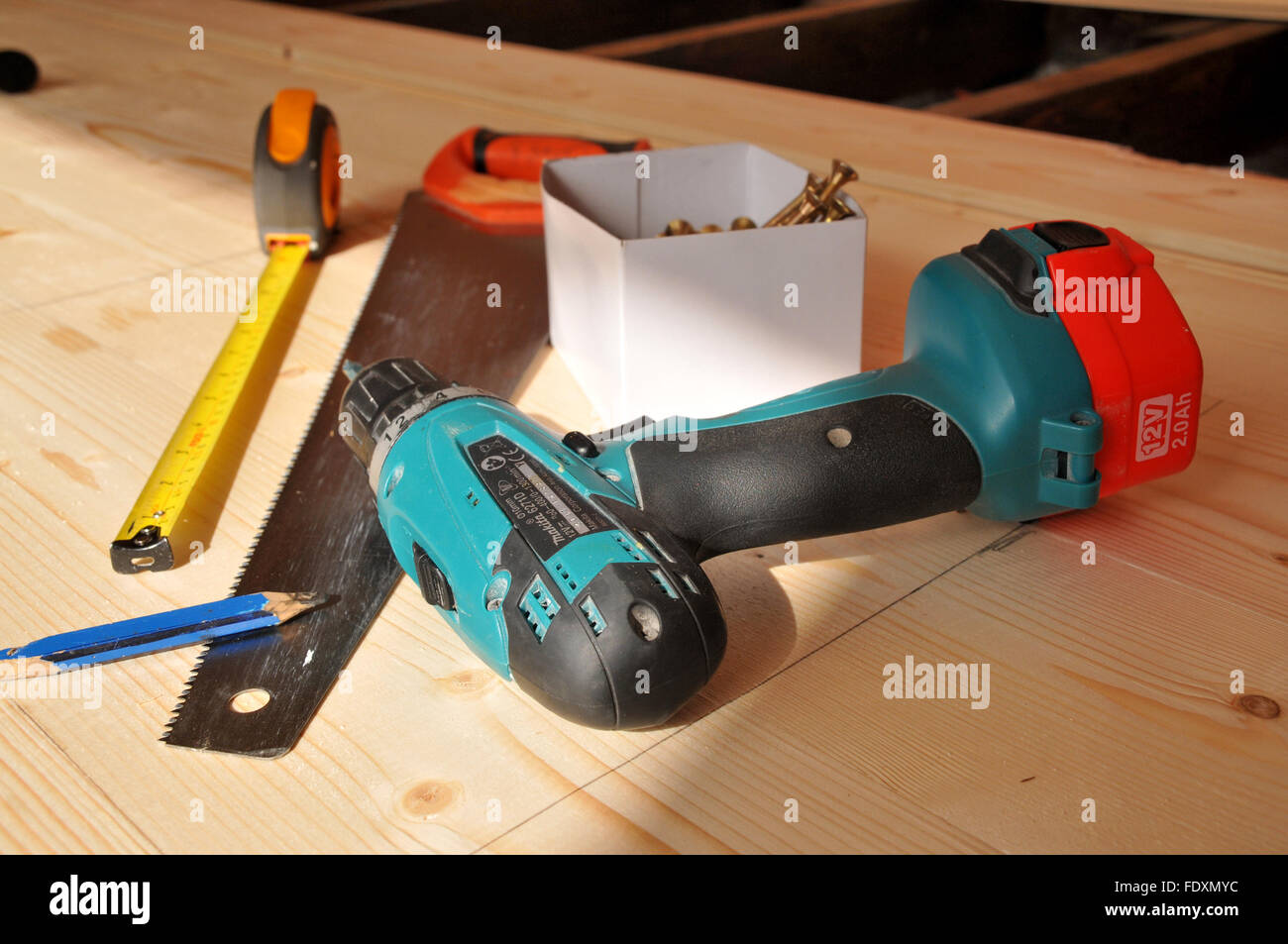 Tischler Werkzeuge auf neuen Holzboden - Bohrmaschine, Handsäge, Bleistift, Schrauben und ein Maßband. Stockfoto