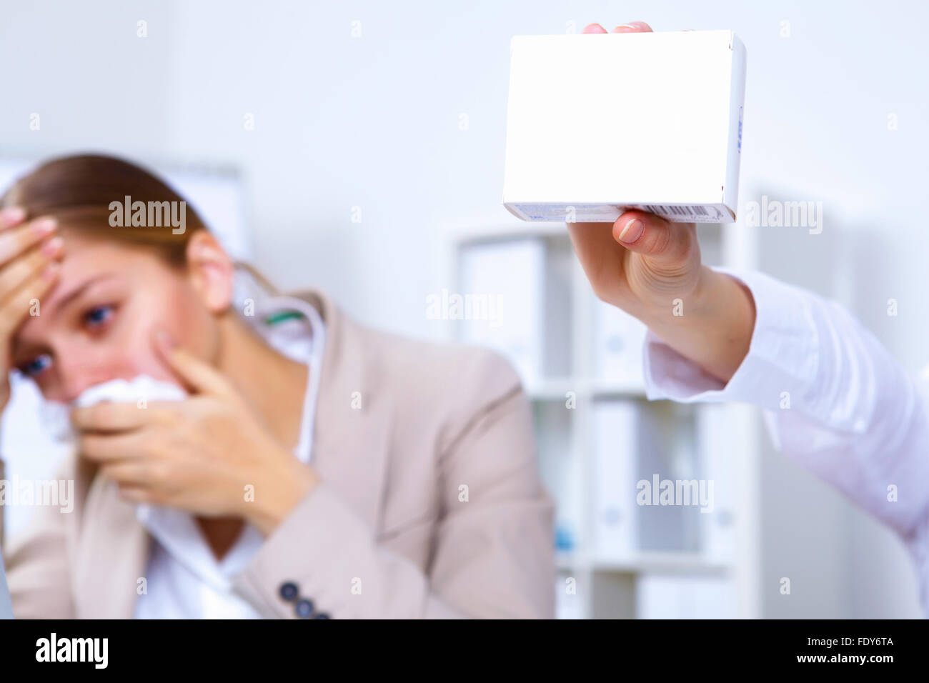 Junge Frau im Amt hält eine Packung von Medizin Stockfoto