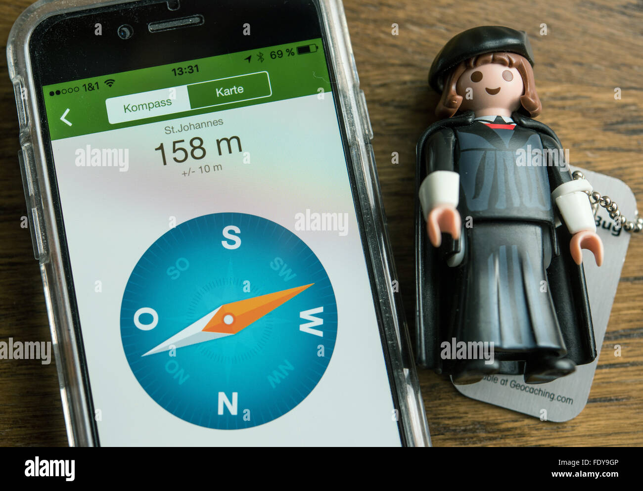 Hohenselchow, Deutschland. 21. Januar 2016. Eine Playmobil-Figur des Martin Luther grenzt direkt an ein Smartphone mit einem Kompass im Dorf Kirche Büro in Hohenselchow, Deutschland, 21. Januar 2016. Lars Fischer des kirchlichen Amtes hat die Martin Luther Playmobil Figur mit Geocaching auf den Weg geschickt. Durch das Reformationsjubiläum wird kleine Luther 36 von seinem ehemaligen Domains in ganz Deutschland besucht haben. Foto: Patrick Pleul/Dpa/Alamy Live News Stockfoto
