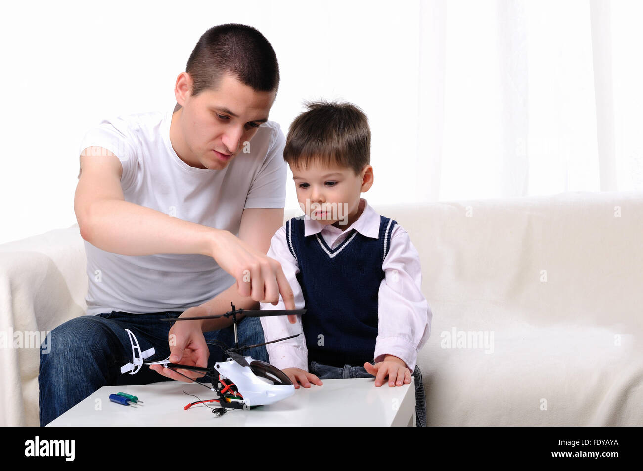 Vater und seinem kleinen Sohn zusammen einen kleinen Hubschrauber zu renovieren Stockfoto