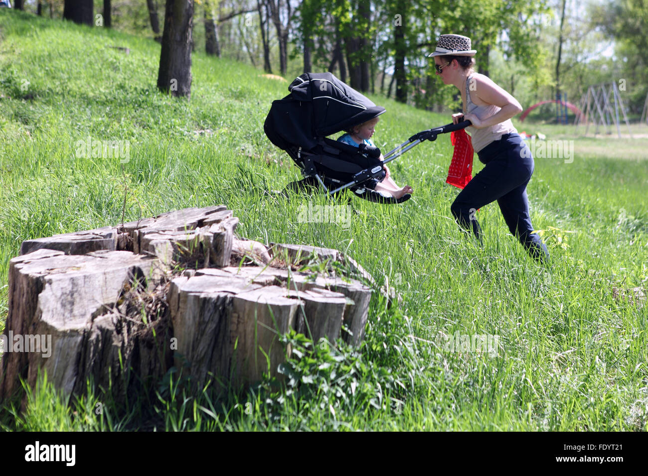Berlin, Deutschland, Frau ihr Kind in einem Kinderwagen bergauf schieben Stockfoto