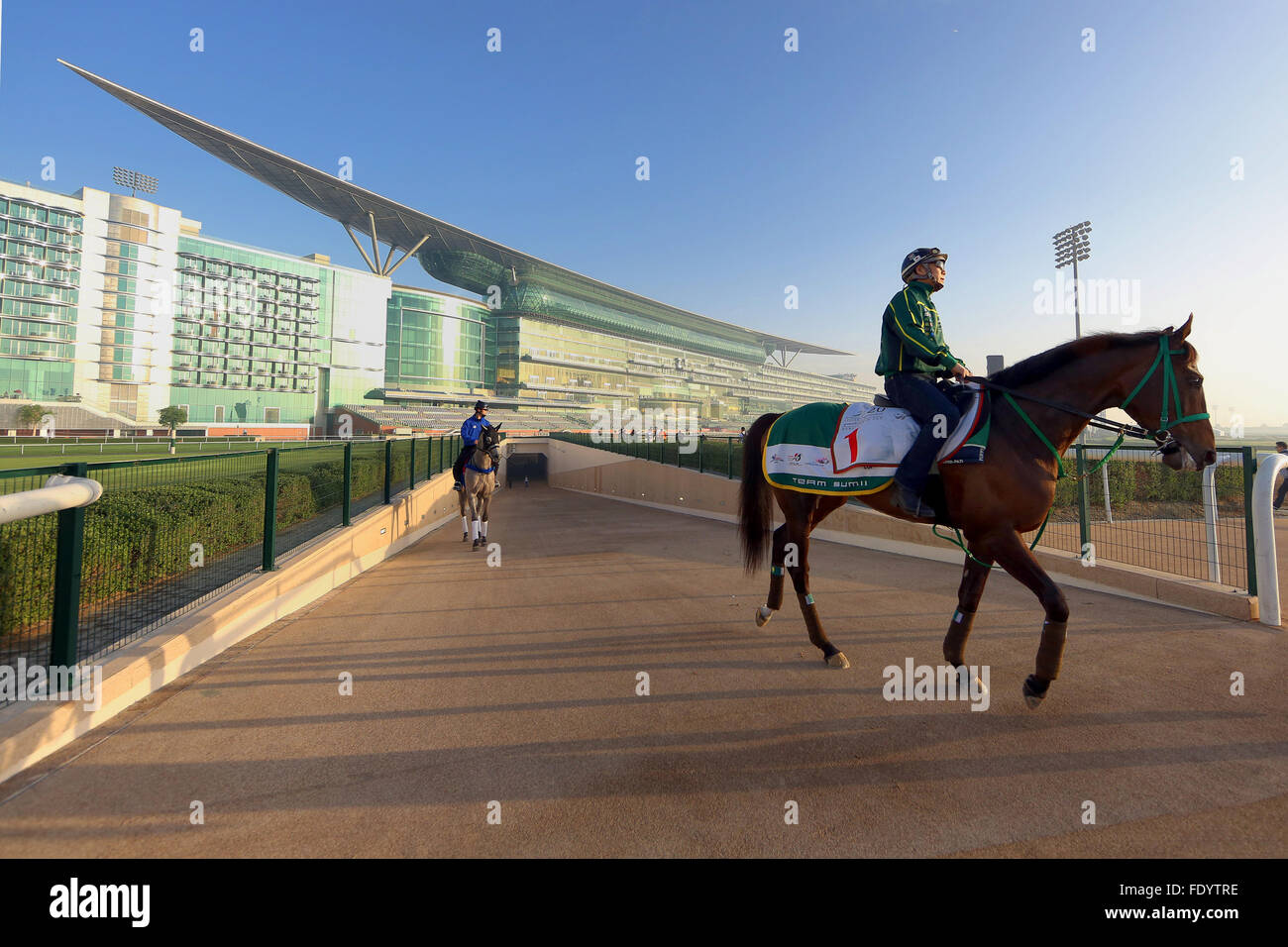 Dubai, Vereinigte Arabische Emirate, Pferde und Reiter vor der Tribüne der Rennbahn Meydan Stockfoto