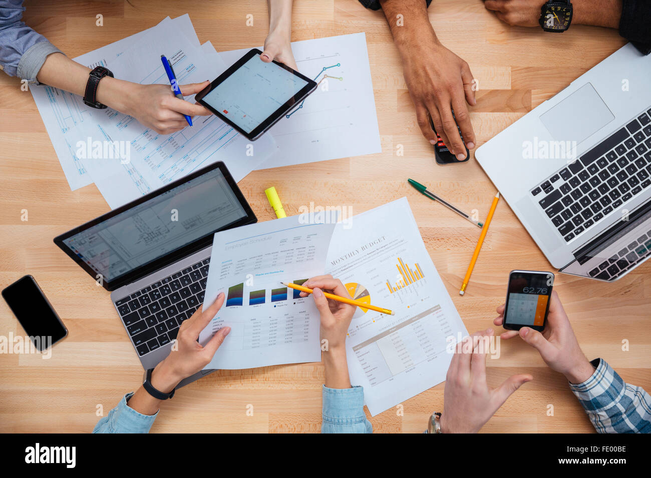 Gruppe von Menschen mit Laptops, Tablets und Smartphones zusammen zu arbeiten und Finanzbericht Stockfoto