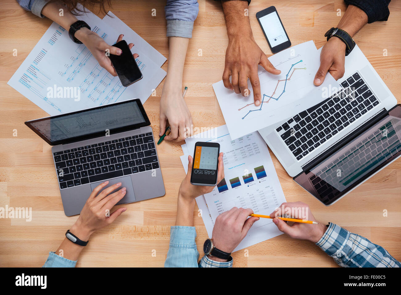 Draufsicht der Gruppe von Geschäftsleuten mit Handys und Laptops und arbeiten für einen Finanzbericht Stockfoto