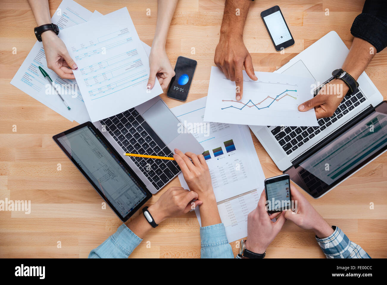 Team von Kolleginnen und Kollegen arbeiten für Finanzbericht mit Laptops und smartphones Stockfoto