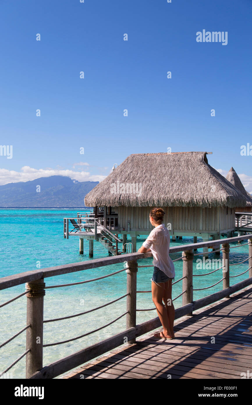 Frau an einem Anlegesteg der Wasserbungalows von Sofitel Hotel, Moorea, Gesellschaftsinseln, Französisch-Polynesien Stockfoto