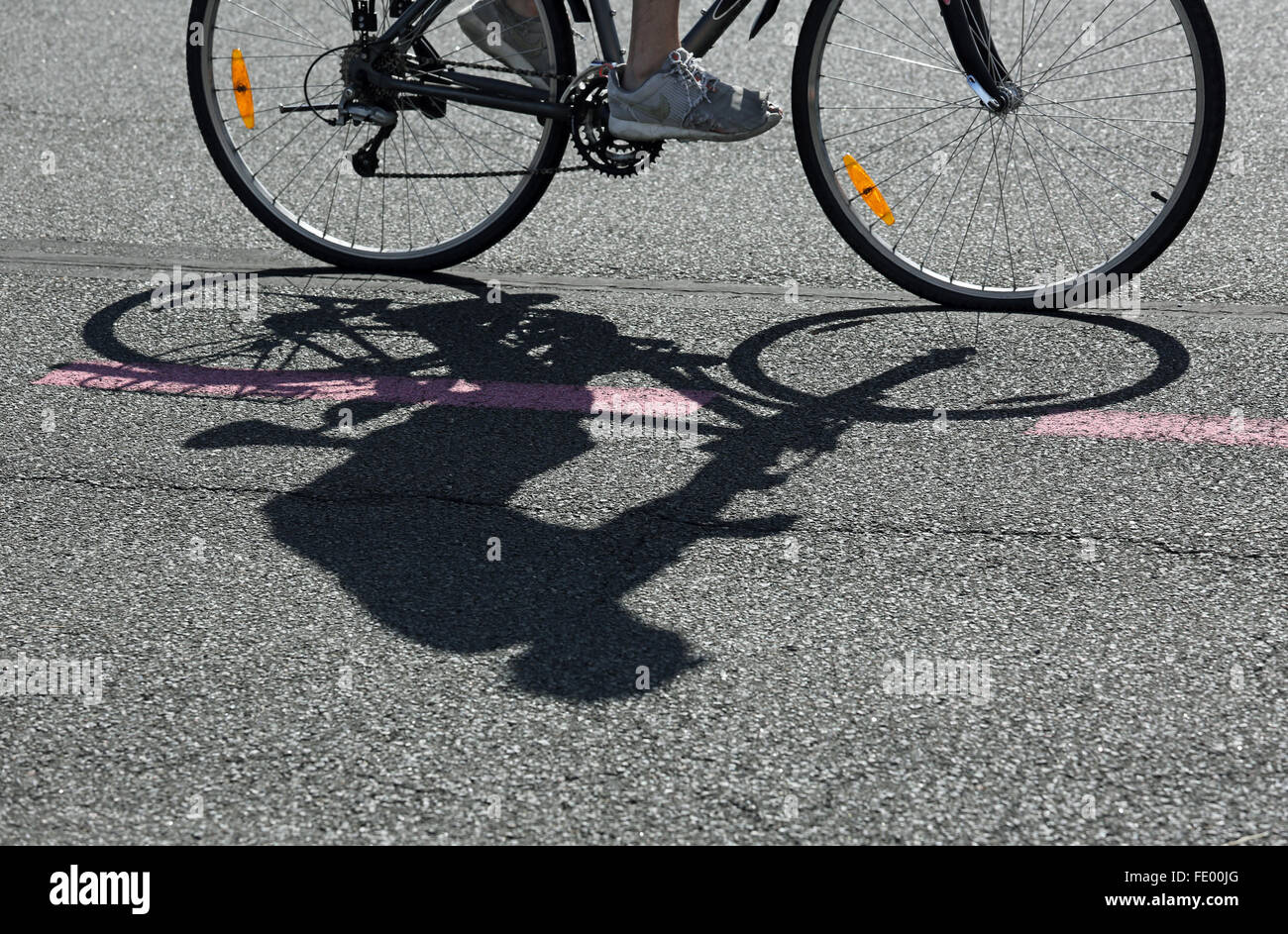 Berlin, Deutschland, Silhouette eines Radfahrers auf asphalt Stockfoto