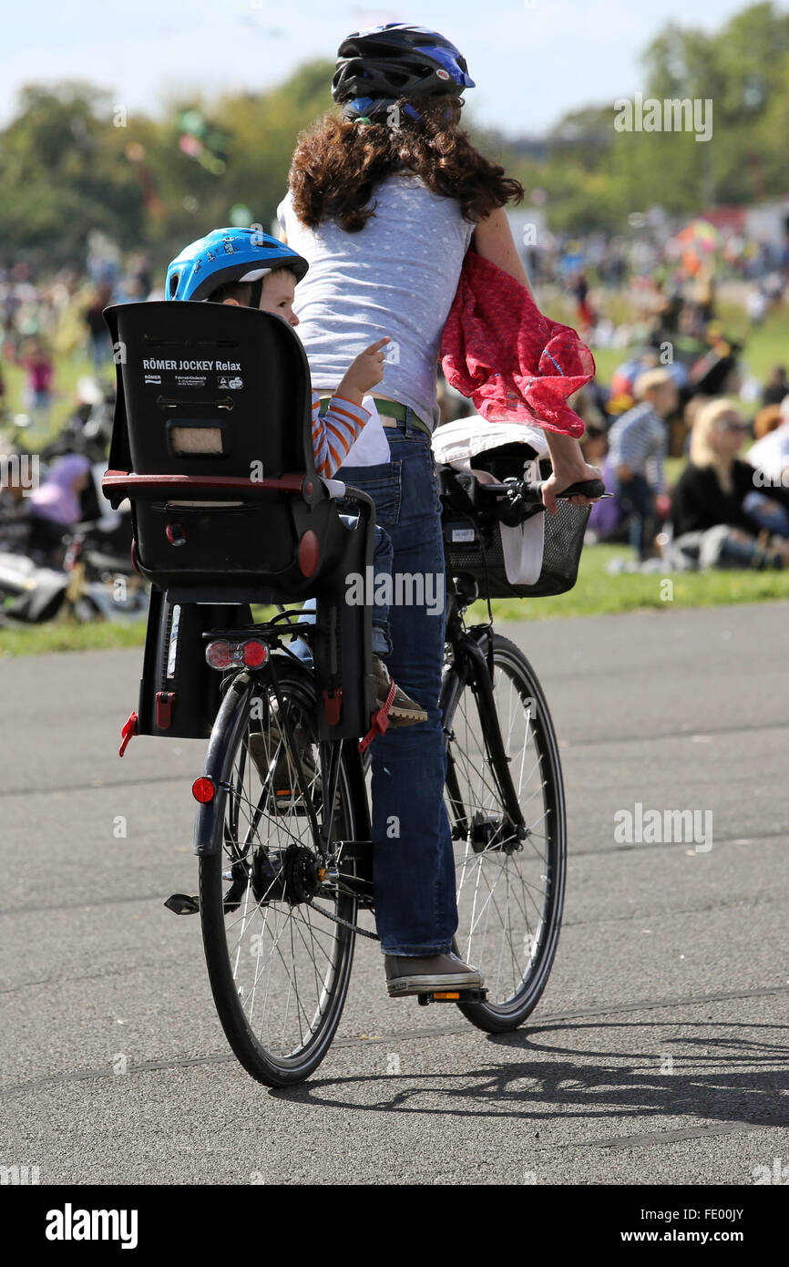 Berlin, Deutschland, treibt Frau mit Kind in einem Kindersitz auf dem Fahrrad Stockfoto