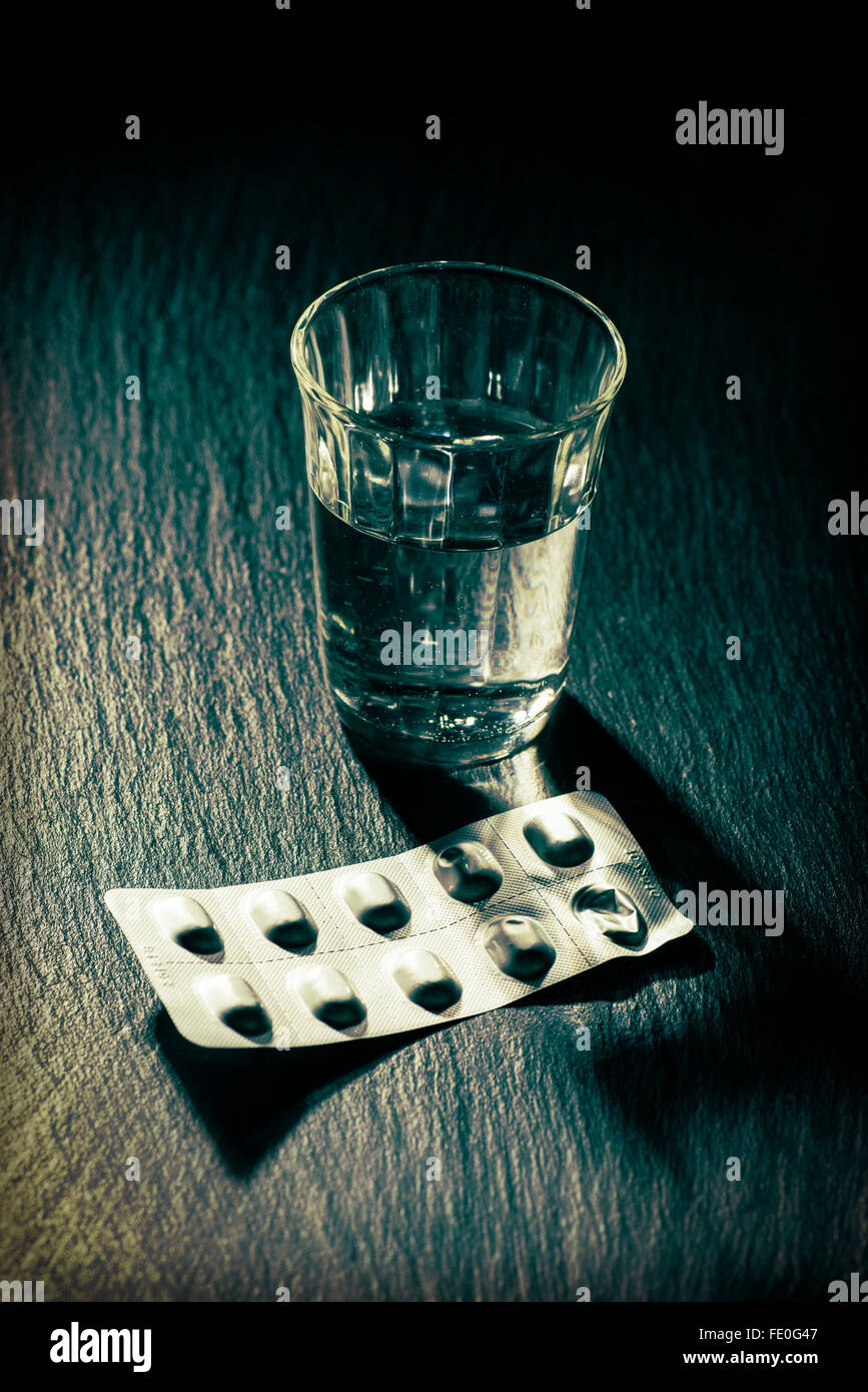 Ein Glas Wasser und ein Blister mit Tabletten Stockfoto