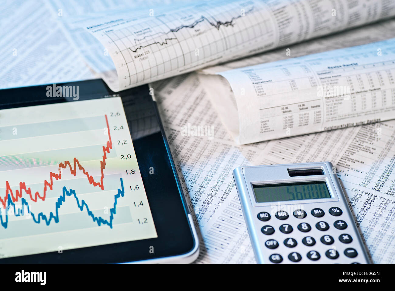 Aktienkurse in der Zeitung und auf dem Bildschirm eines Tablet-Computers. Stockfoto
