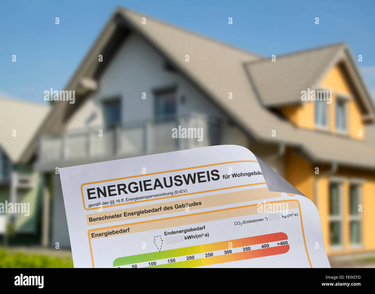 Energieausweis mit einem freistehenden Haus im Hintergrund. Stockfoto