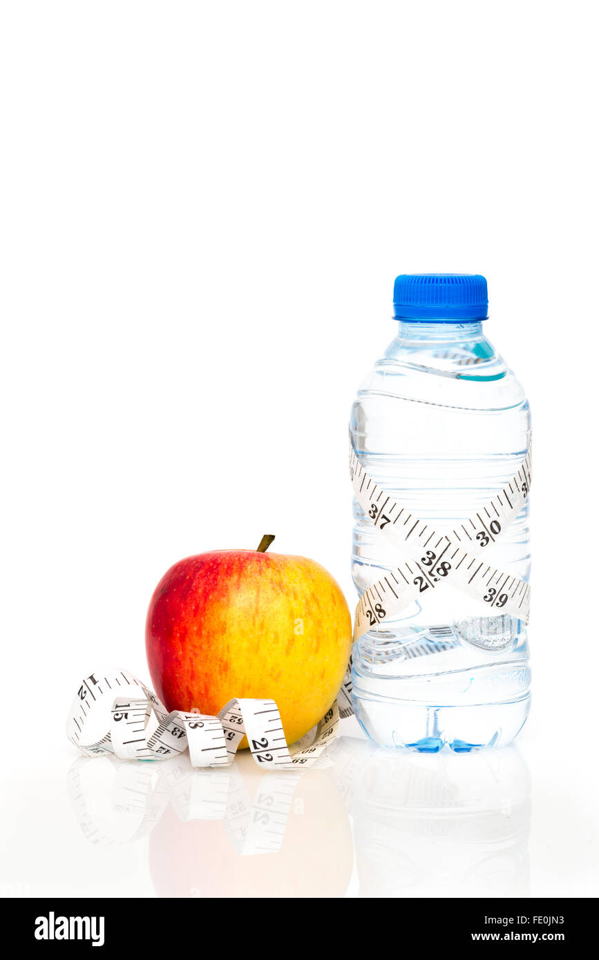 Flasche Wasser verpackt in weiße Kaiserliche Maßband mit roten Apfel isoliert auf weißem Hintergrund mit Textfreiraum Stockfoto
