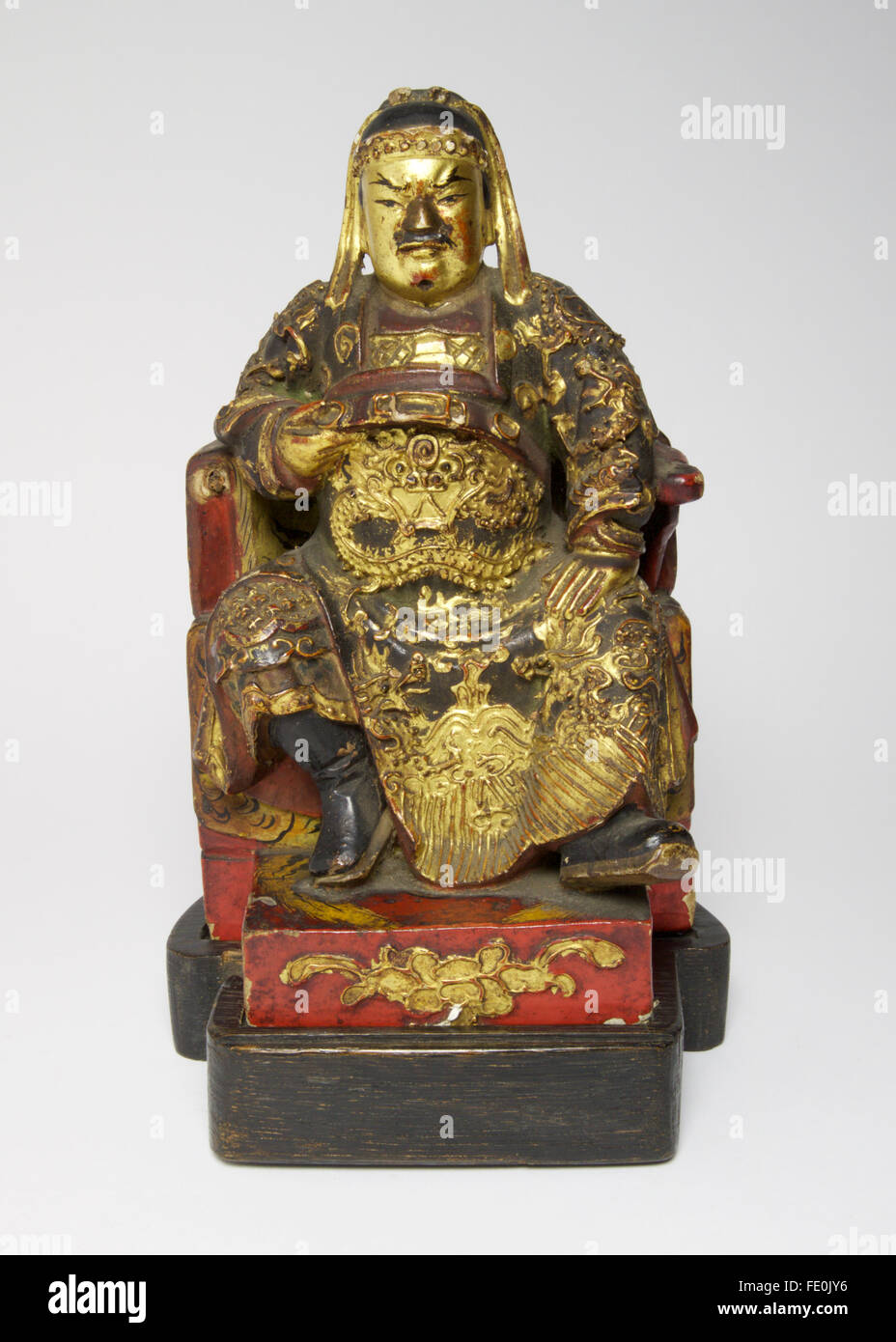 Antike chinesische Polychrome lackierte Holzfigur Guandi dargestellt sitzende mit einer Hand hob und umklammern den Gürtel. Stockfoto