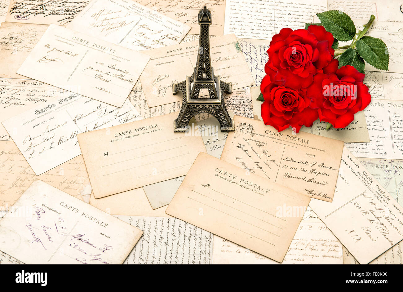 Rote Rosen, alte Briefe und Souvenir Eiffelturm von Paris. Nostalgisch reisen Hintergrund Stockfoto