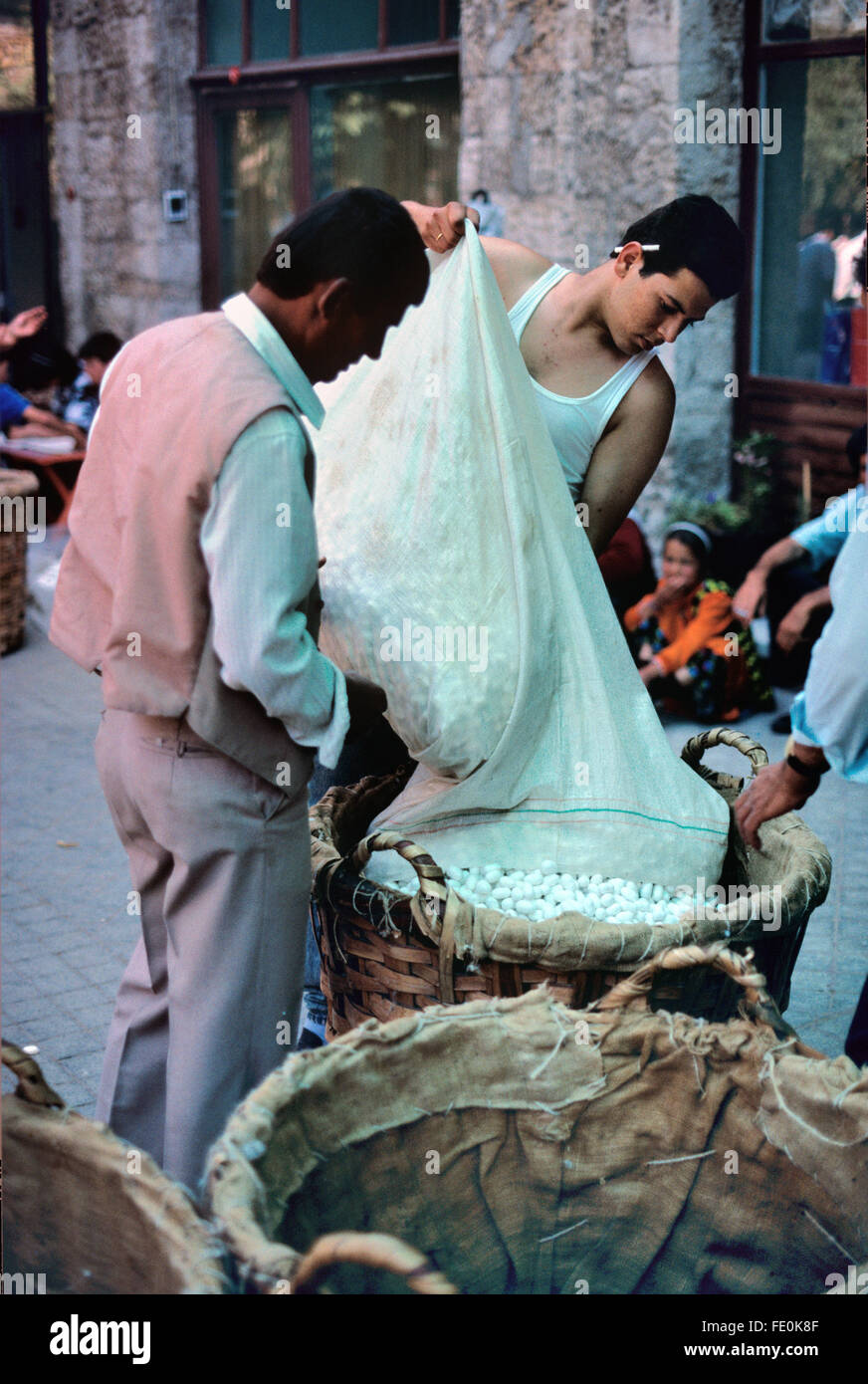 Seide Bauern wiegen Beutel aus Seide Kokons im Silk Cocoon Markt findet jährlich im Juli, wenn die Bauern ihre Seide Seide Kokons, in der Seide Basar, oder Koza Han, Bursa, Türkei verkaufen Stockfoto