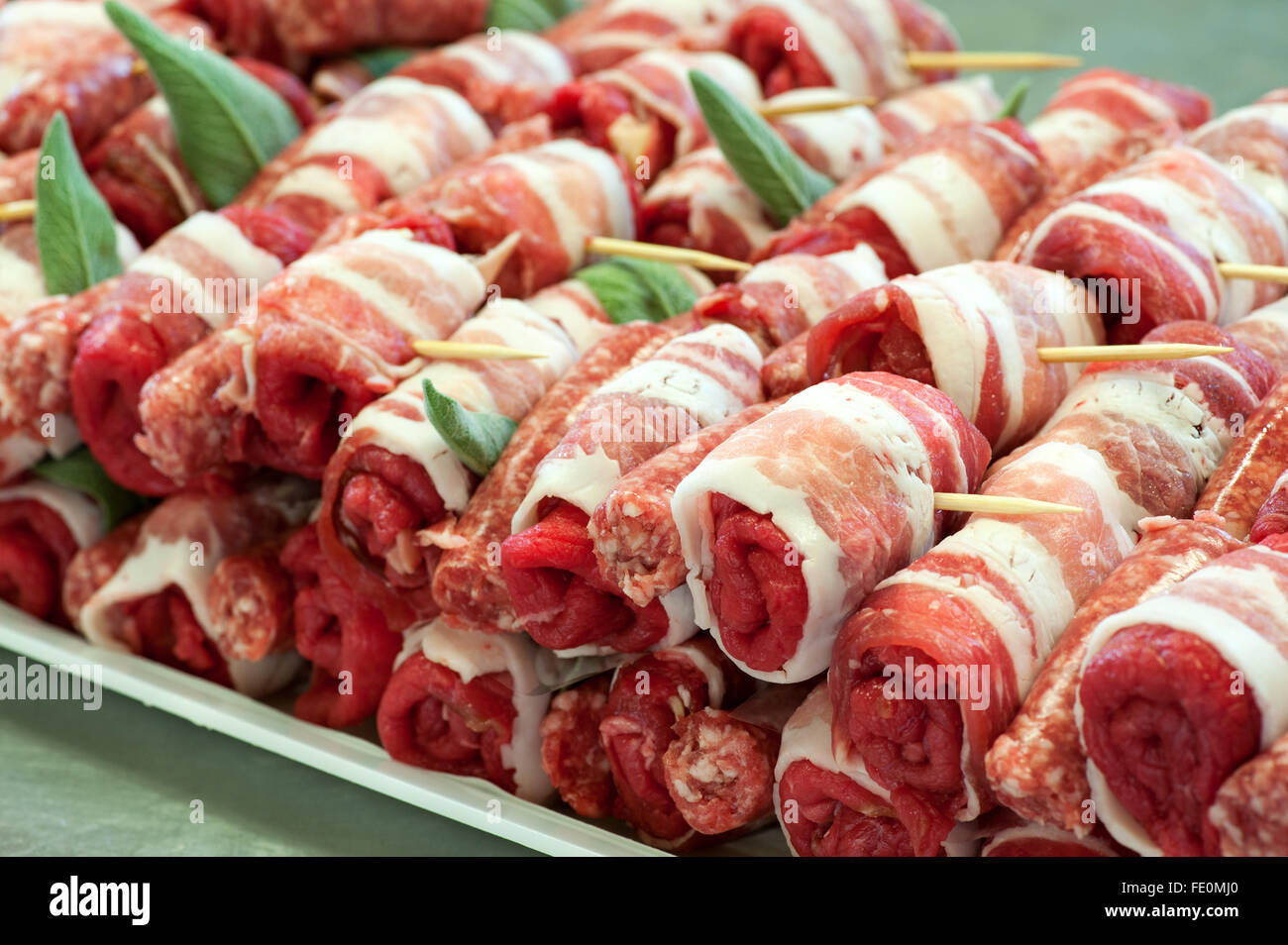 Nahaufnahme eines vollen Tablett mit rohes, rotes Fleisch Rollen mit Salbeiblättern und Zahnstocher bereit, für Vorspeisen kochen Stockfoto