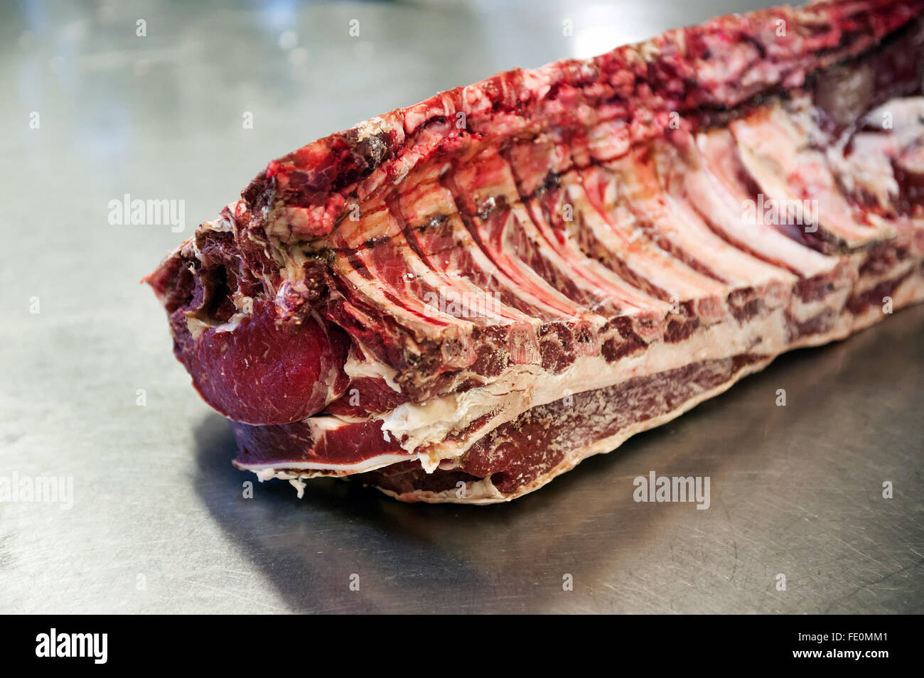 Nahaufnahme von rohen Rib-Eye Steak Abschnitt auf Metall Tisch in Fleischverarbeitungsbetrieb Stockfoto