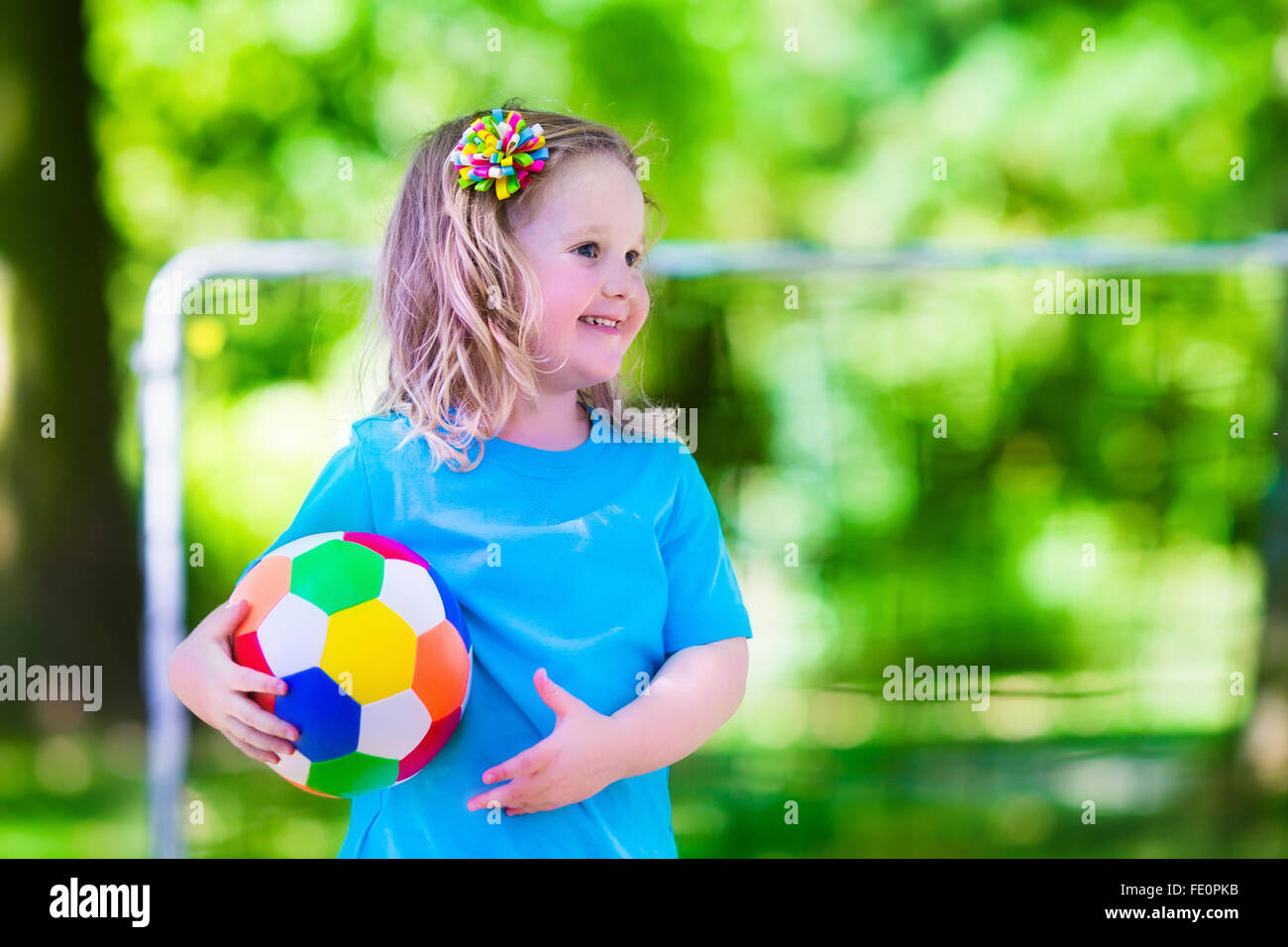 Zwei glückliche Kinder spielen Fußball im Freien im Schulhof. Kinder spielen Fußball. Aktiv Sport für Vorschulkind. Stockfoto