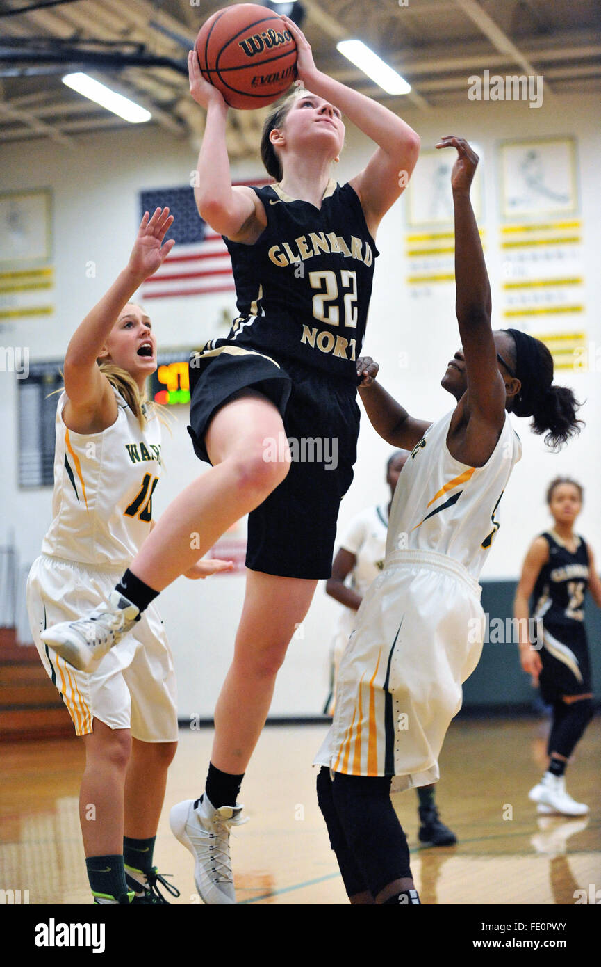 Eine zerstreute sich auf einem Flug nach Ergebnis vor ein paar Verteidiger während eines High School Basketball Spiel. USA. Stockfoto