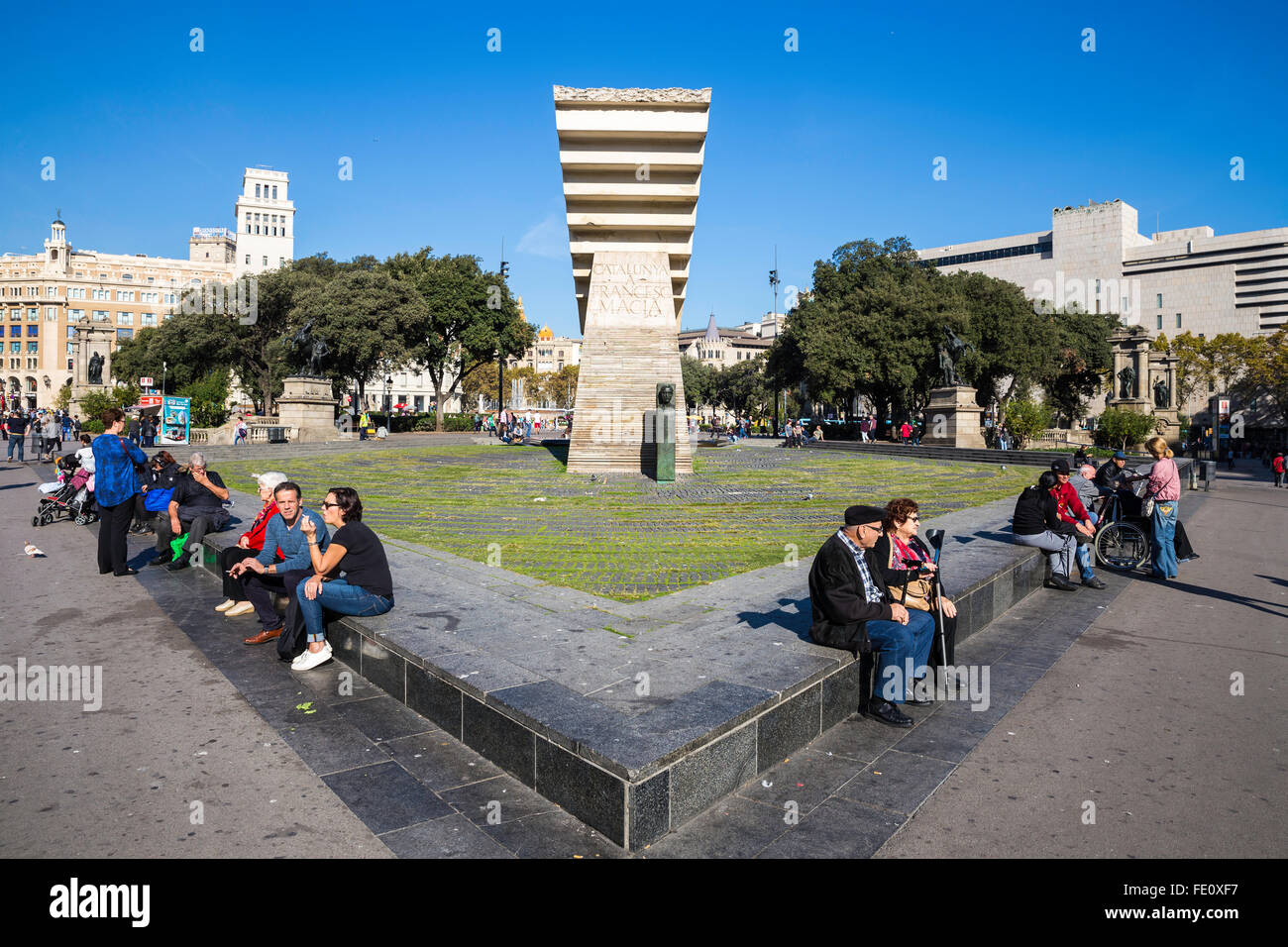 Tourist-Leute sitzen in der Nähe von Denkmal für Francesc Macia an der Placa de Catalunya, Barcelona, Spanien Stockfoto