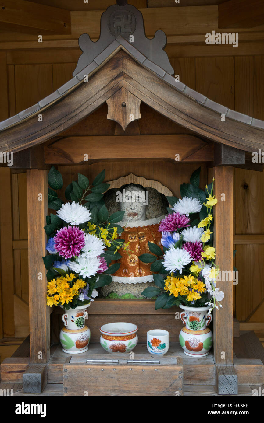 lokalen buddhistischen Tempel display mit Porzellan und Blumen Stockfoto