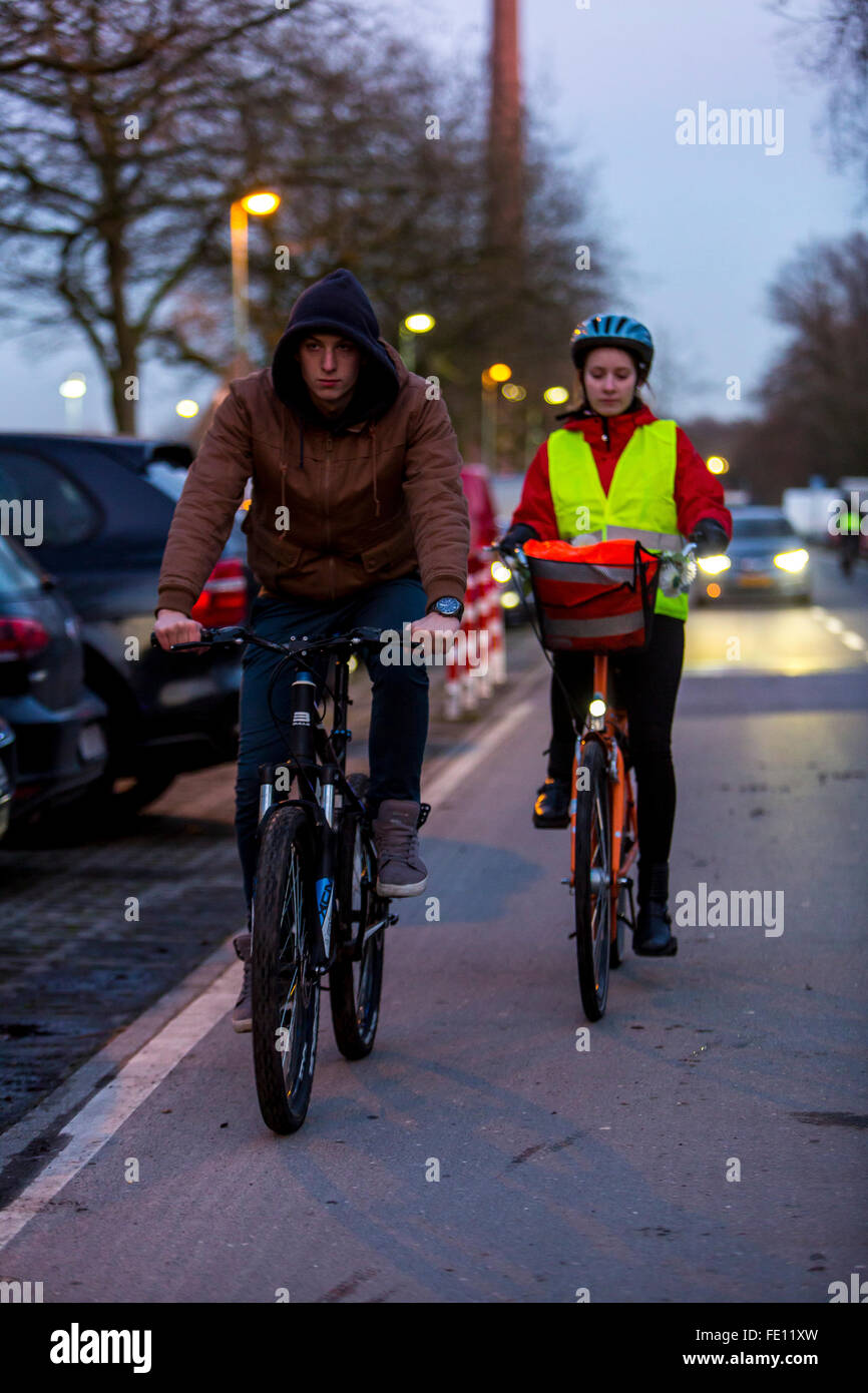 Radfahrer fahren, in der Dämmerung, in einer Stadtstraße, mit und ohne  Beleuchtung und Sicherheitskleidung, Fahrrad Sicherheit, Sichtbarkeit bei  Nacht Stockfotografie - Alamy