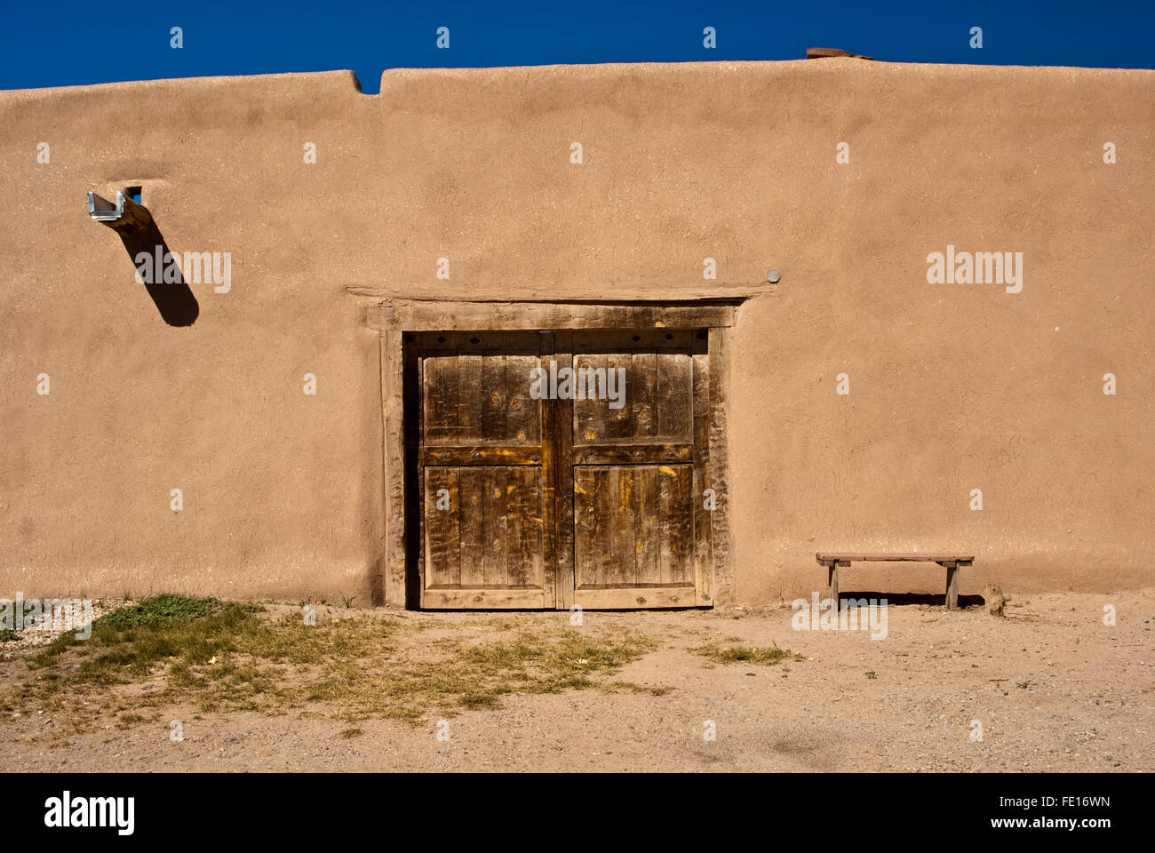 Adobe Gebäude mit alten Tür und Bank in New Mexico, USA Stockfoto