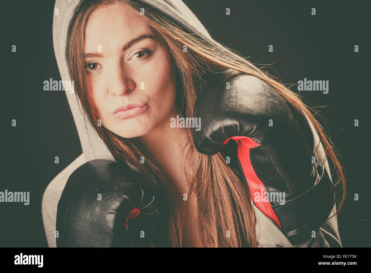 Boxen und Weiblichkeit. Sportlerin mit Kapuze mit Black-Box-Handschuhe Stockfoto