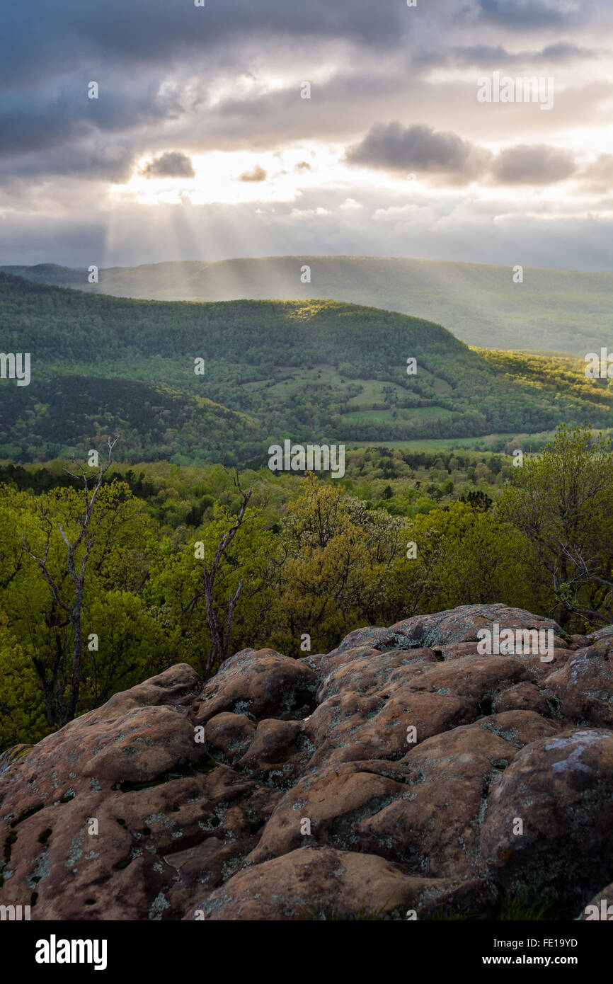 Sonnenstrahlen durch bewölkter Himmel über Felsen bluff Stockfoto