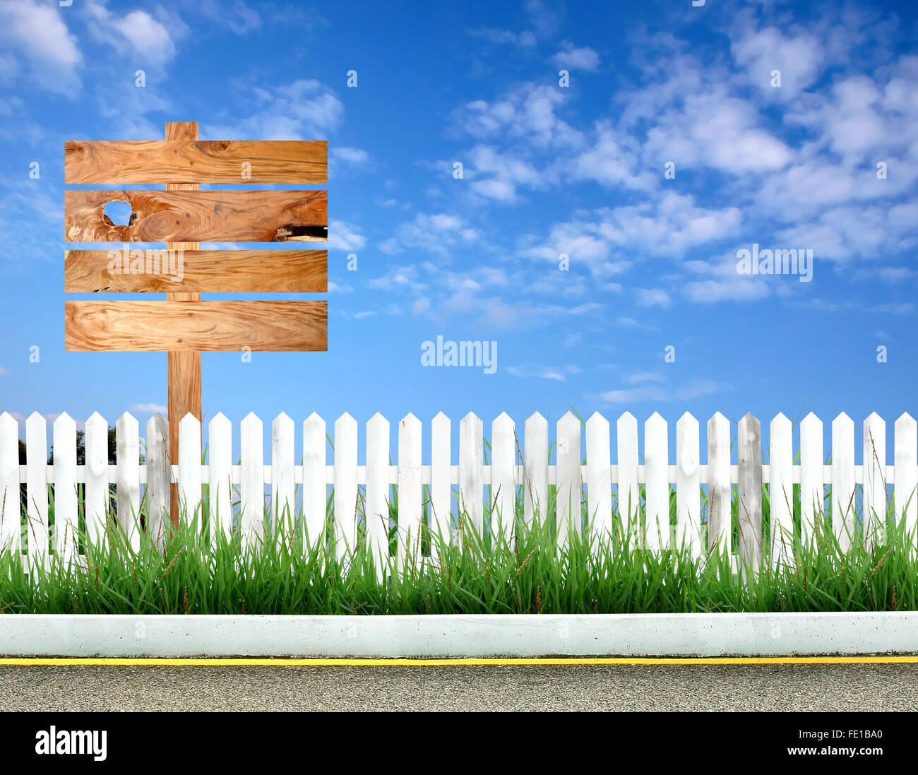 Wegweiser aus Holz mit weißer Zaun und blauer Himmel Stockfoto