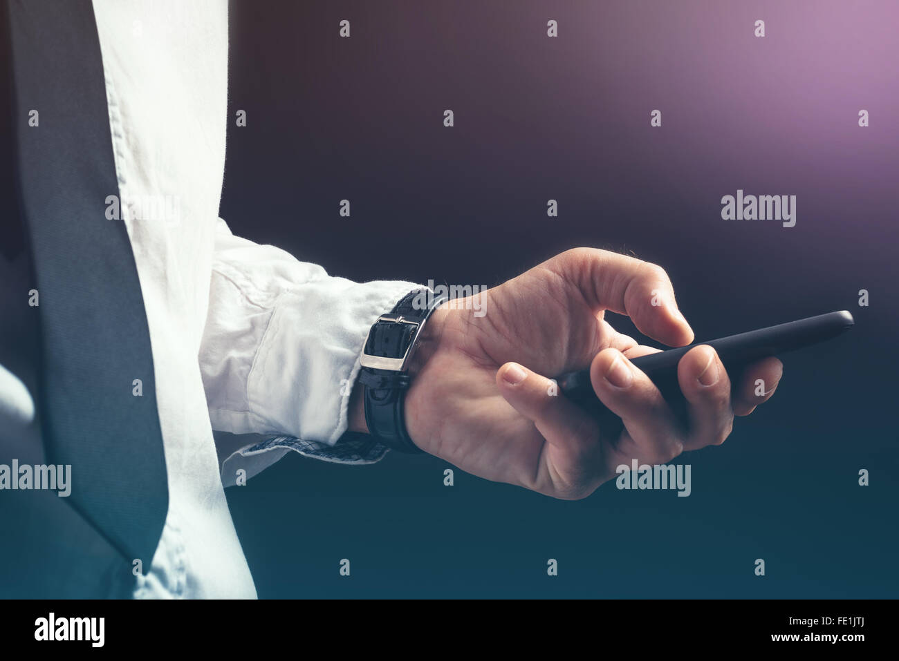 Jungunternehmer unkenntlich professionelle SMS auf Smartphone mit Nachricht app in dunklen Büroeinrichtung. Stockfoto