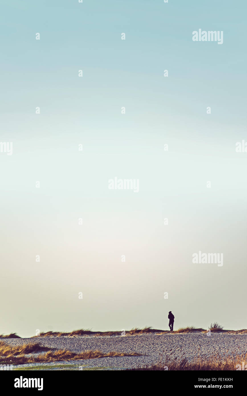 Unerkennbar Person zu Fuß auf Ödland Horizont, Retro getönten Bild mit Himmel als Textfreiraum Stockfoto