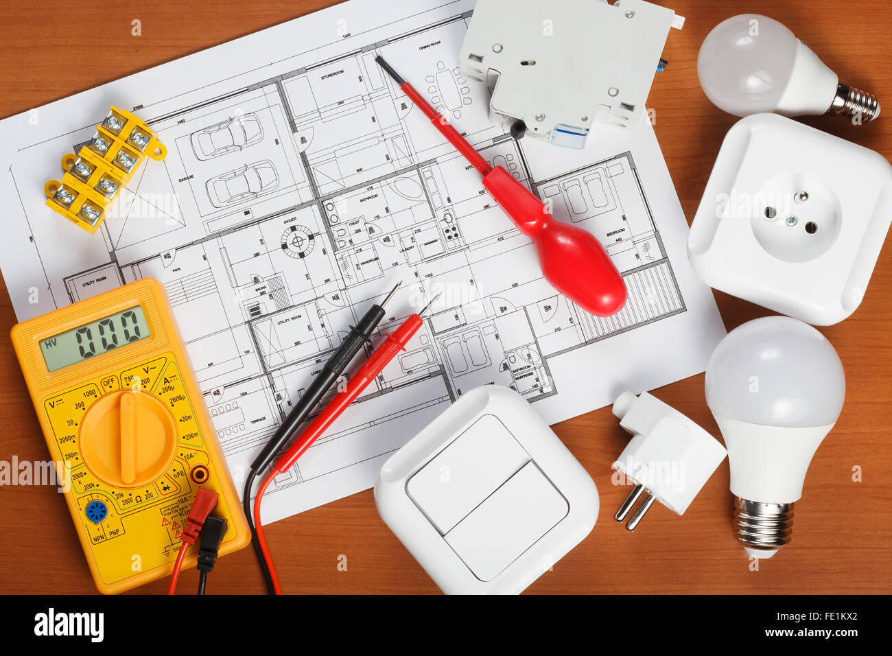 Elektrische Geräte, Werkzeuge und Hauspläne auf dem Schreibtisch Stockfoto