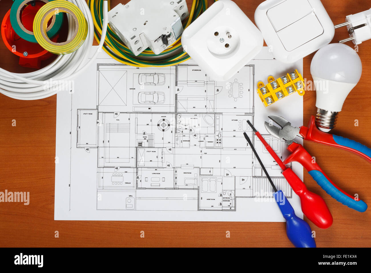 Elektrische Geräte, Werkzeuge und Hauspläne auf dem Schreibtisch Stockfoto