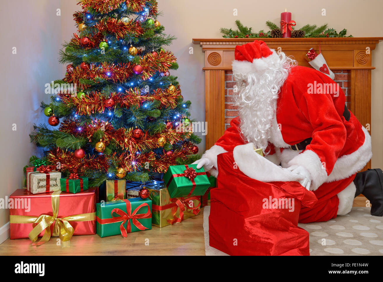 Santa Claus liefert Geschenke zu einem Haus und nehmen Geschenke von seinen sack Stockfoto