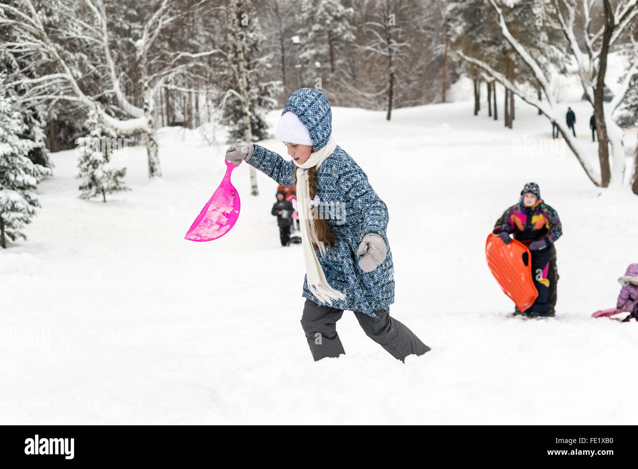 UFA - Russland 16. Januar 2016 - Kinder genießen den frischen Schnee mit improvisierten Folien und Schlitten hinunter Schnee Banken in Stockfoto