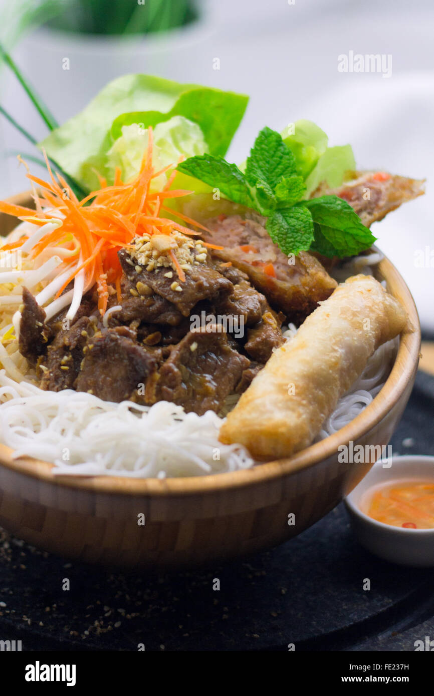 Bun Thit Vietnamesisch Reis Vermicelli in Holzschale mit Salat, Schweinefleisch, Cha Gio, Da Nang Springroll, südostasiatischen Stil Essen Stockfoto