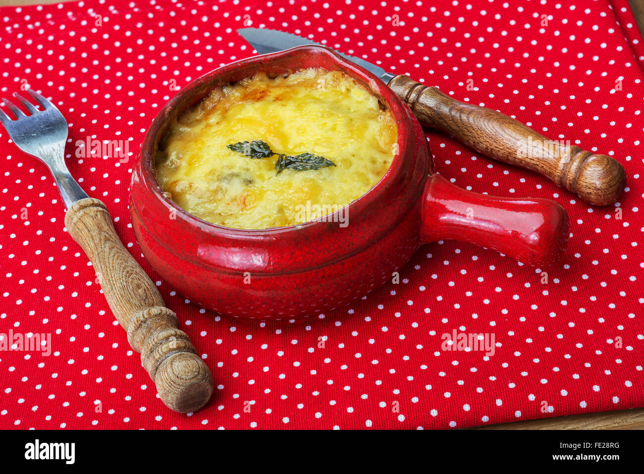 Julienne mit Champignons, Sahne und Käse auf roten Tupfen Tischdecke Stockfoto