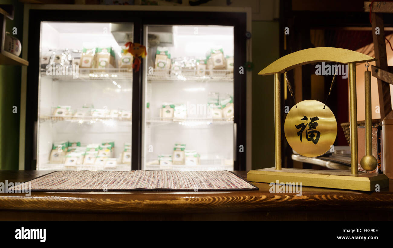 Tee-Kaffee-Shop unscharf Hintergrund, hölzerne bar. Bambus, Matte und Glocke mit chinesischen Schriftzeichen Wünsche Glück, Glück. Stockfoto