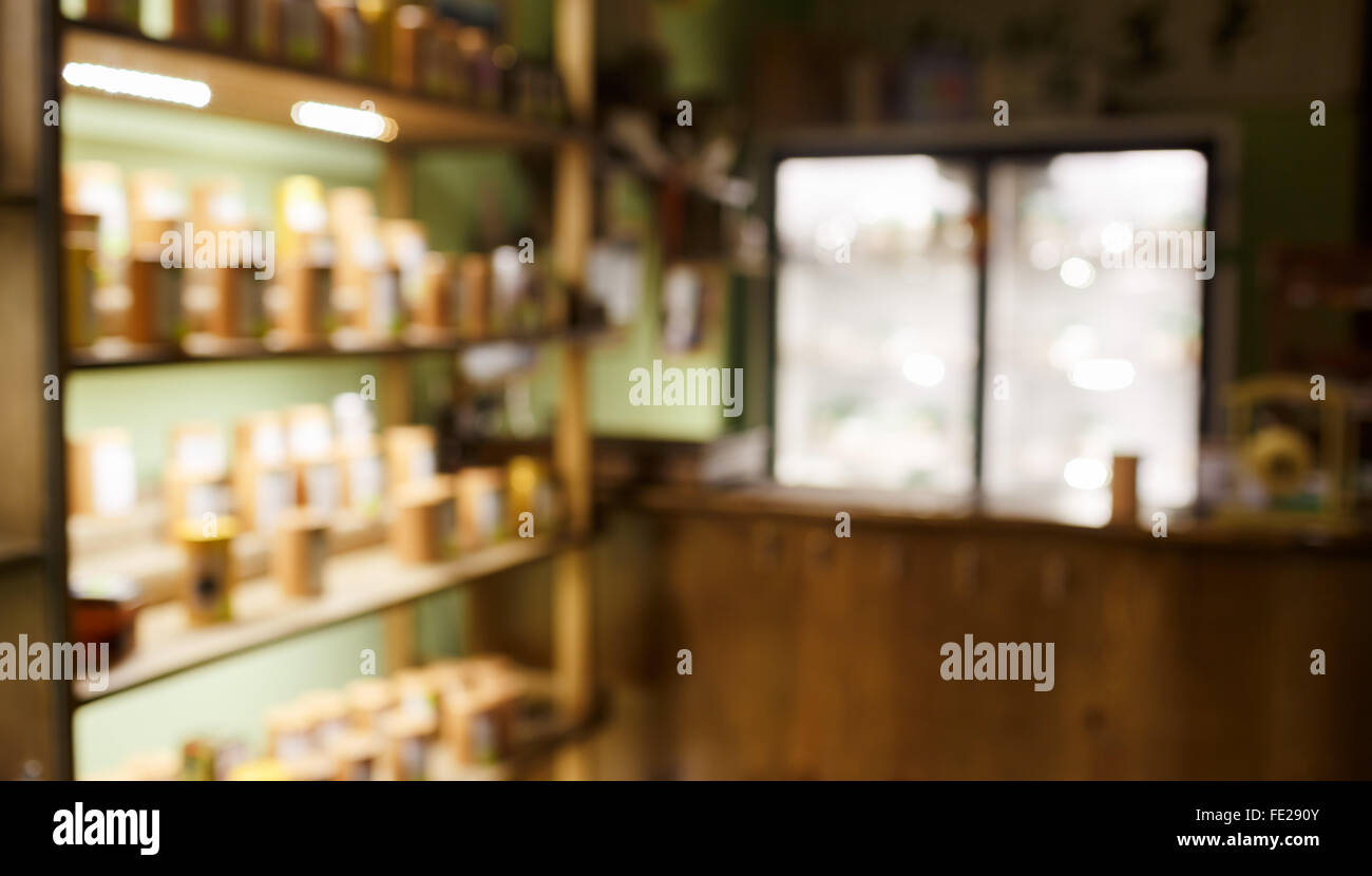 Tee Kaffee Shop Innenraum abstrakte Hintergrundunschärfe, Regale mit Proben, Hintergrundbeleuchtung und beleuchteten Schaufenster. Stockfoto