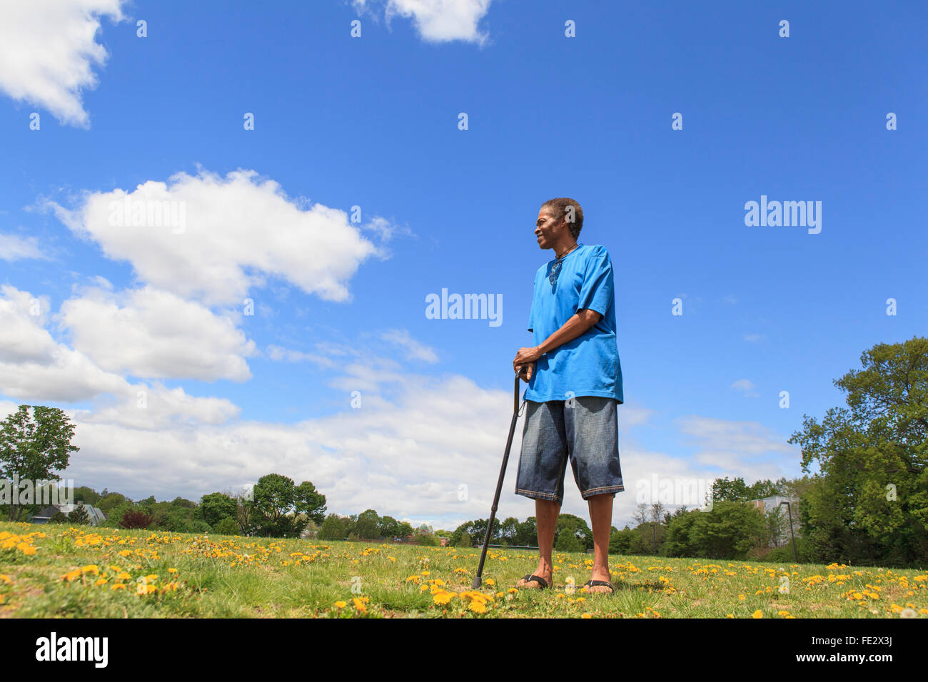 Mann mit Schädel-Hirn-Trauma bei einem Spaziergang mit seinem Stock in einem park Stockfoto
