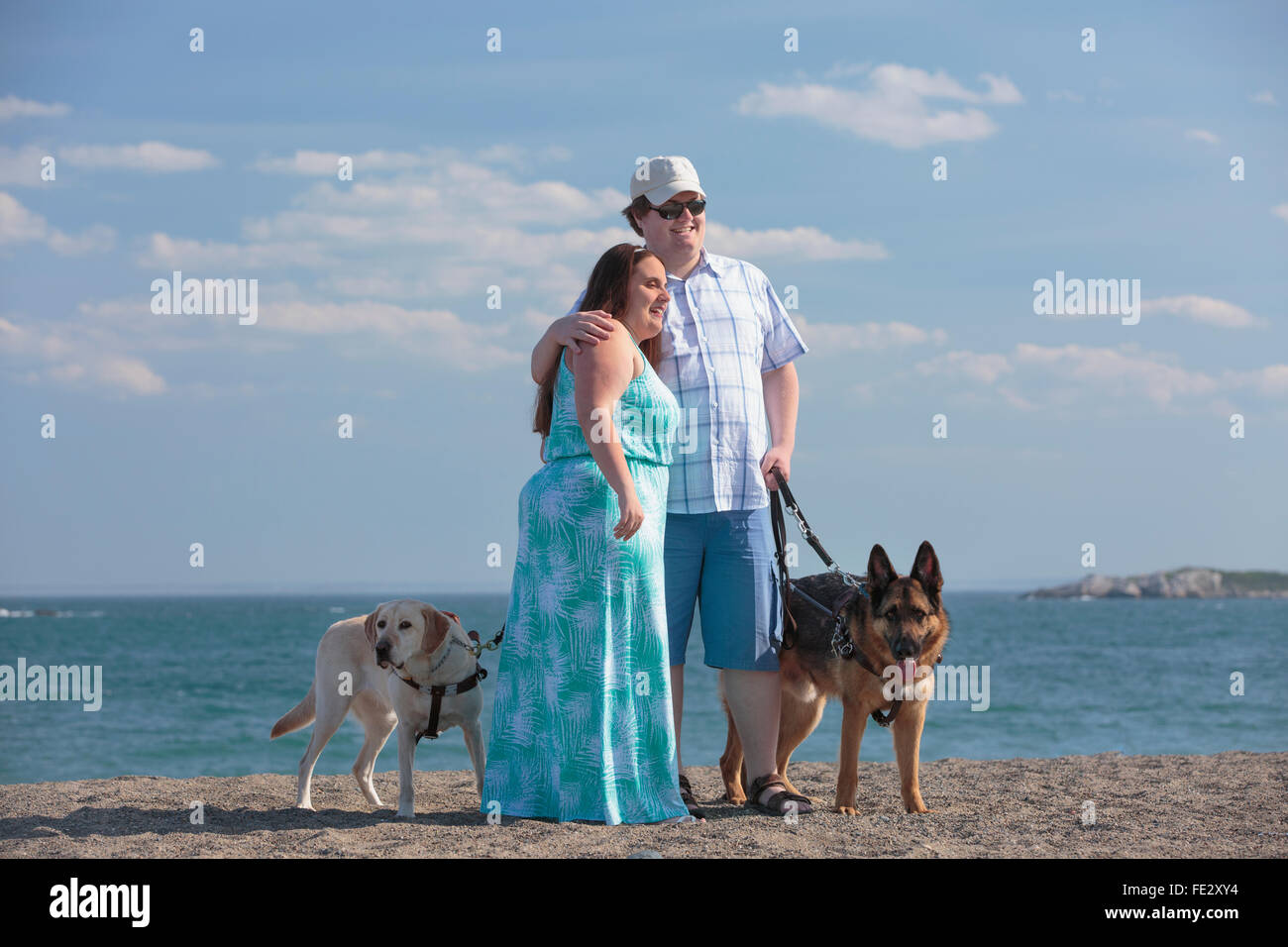 Junges Paar mit Sehbehinderungen und Service-Hunde am Strand Stockfoto