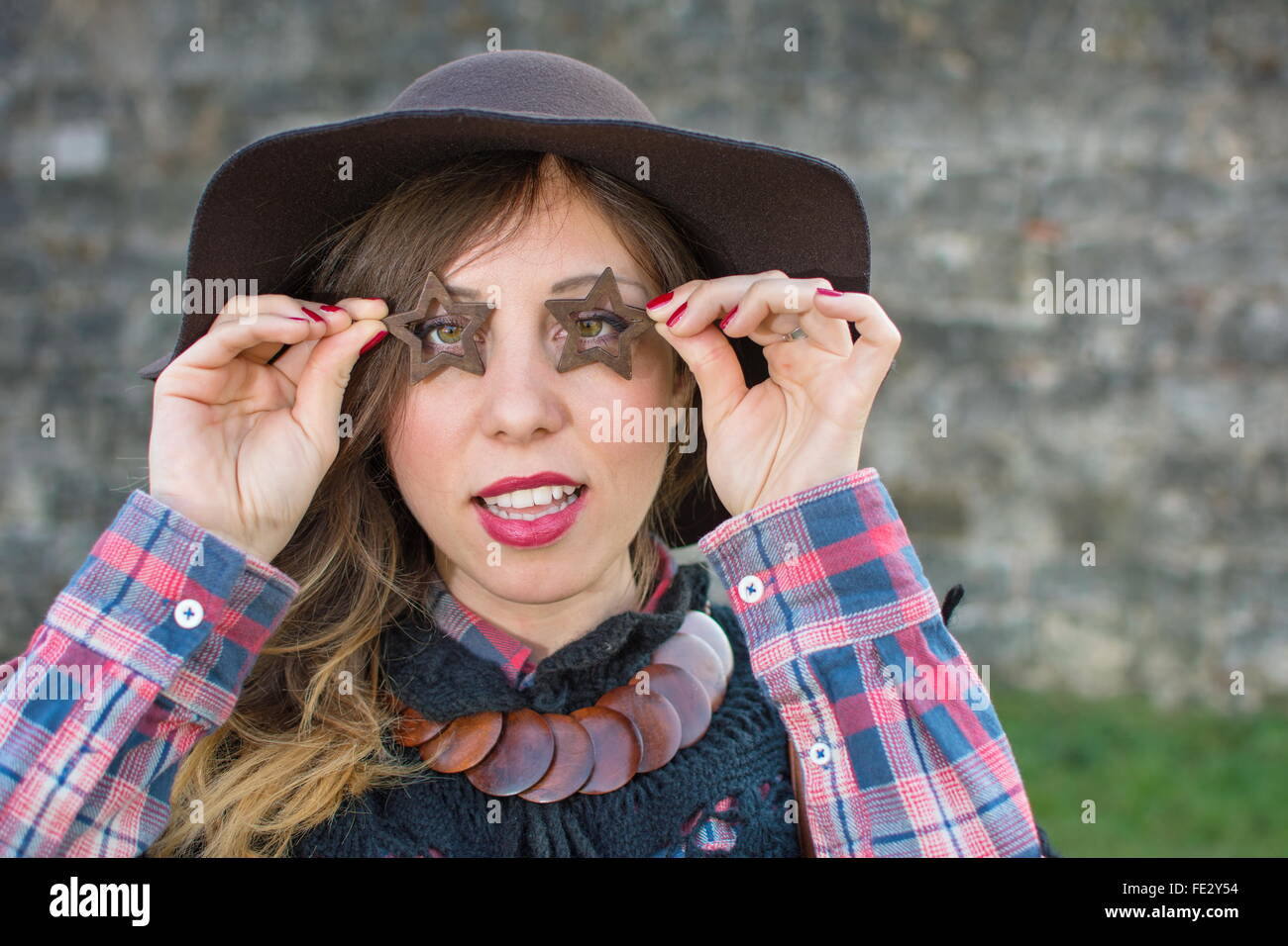 Schöne Mädchen auf der Suche durch Sterne geformt Ohrringe im freien Stockfoto