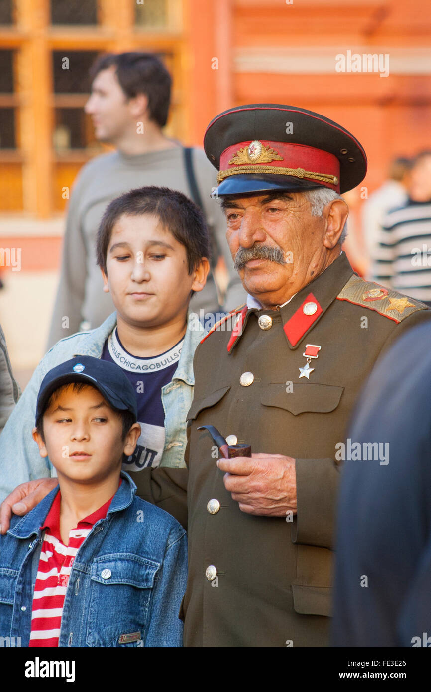 Zentrale asiatische Jungs posieren für ein Foto mit einem Stalin-Imitator außerhalb der State History Museum, Moskau, Russland Stockfoto