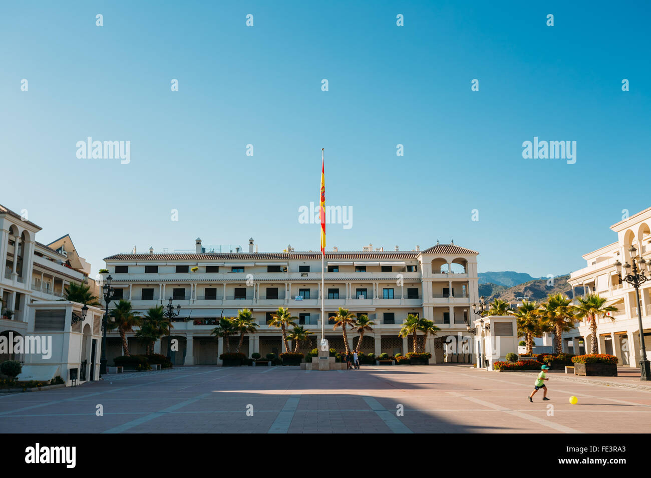 Sommer Sonnenschein, blauen Himmel, auf dem Stadtplatz mit einer Fahne und weißen Häusern in Nerja, Andalusien, Spanien. Europa. Stockfoto