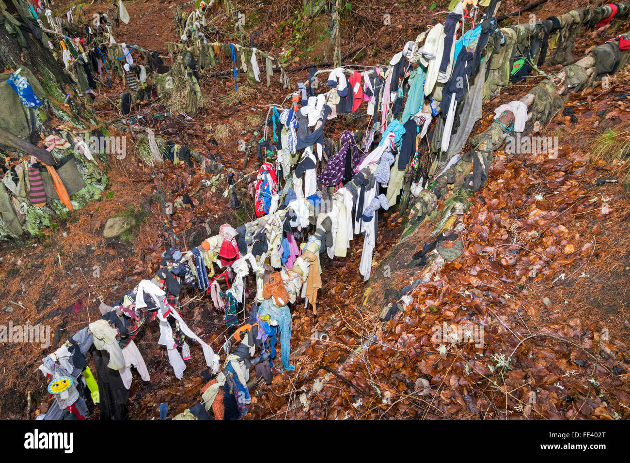 CLOOTIE GUT MUNLOCHY BLACK ISLE SCHOTTLAND KLEIDUNG AUF ÜBERLADENE ZWEIGEN NACH DEM VERLAUF DES WASSERS AUS DEM BRUNNEN Stockfoto